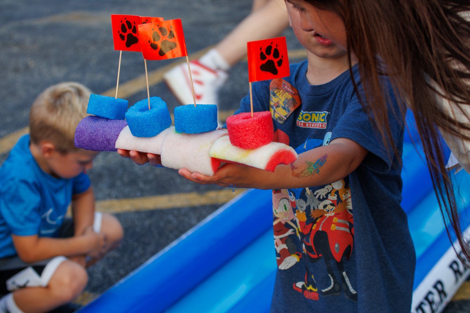 Child holding a colorful foam boat made at National Night Out