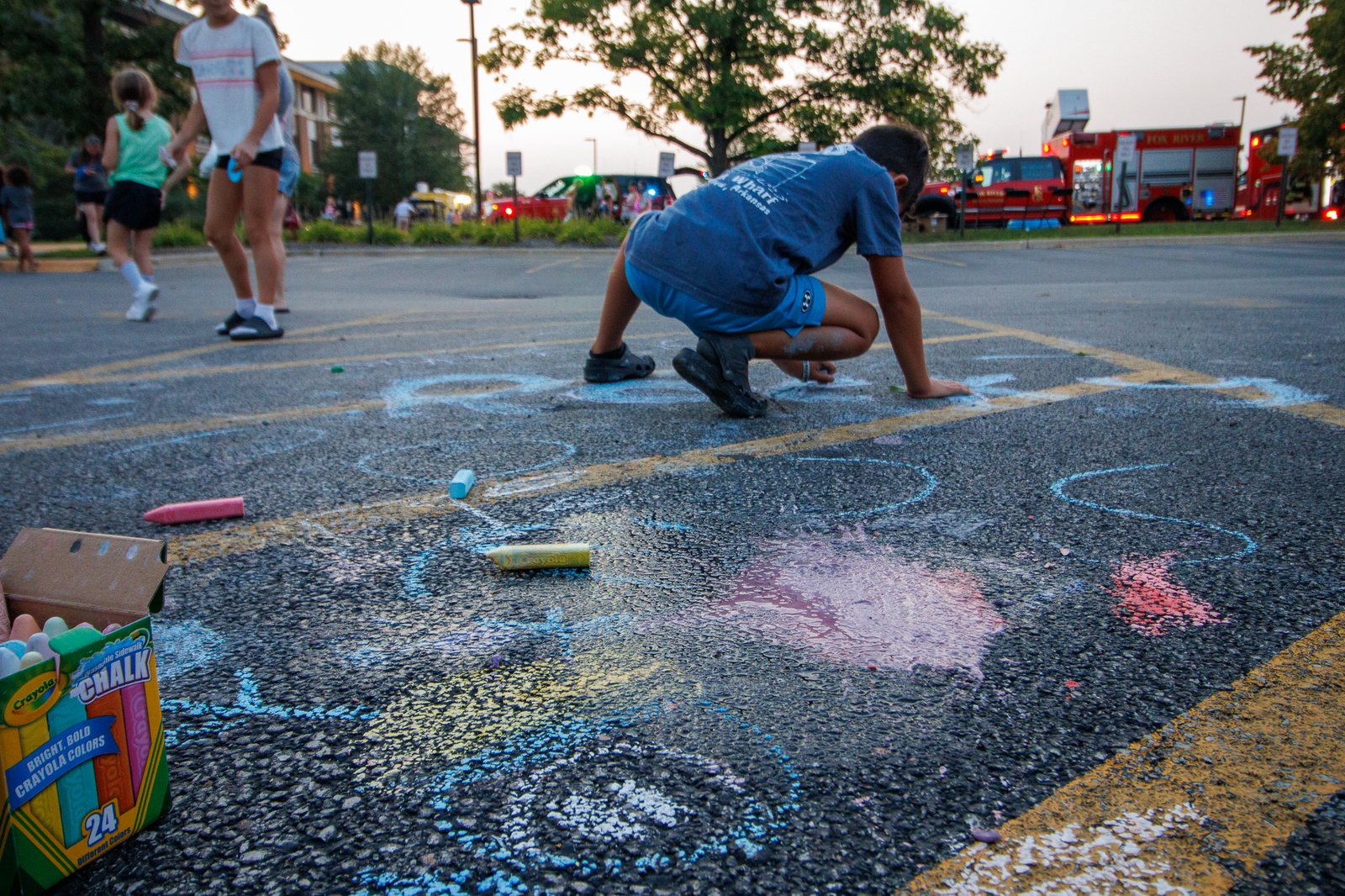 Child drawing with sidewalk chalk at National Night Out