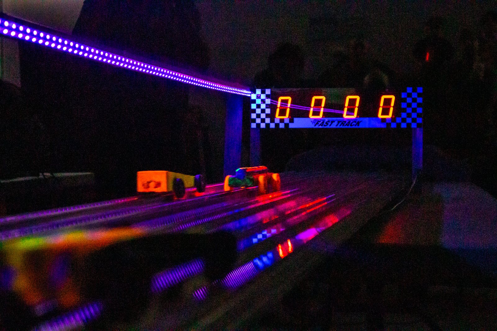 Pinewood Derby cars crossing the illuminated finish line