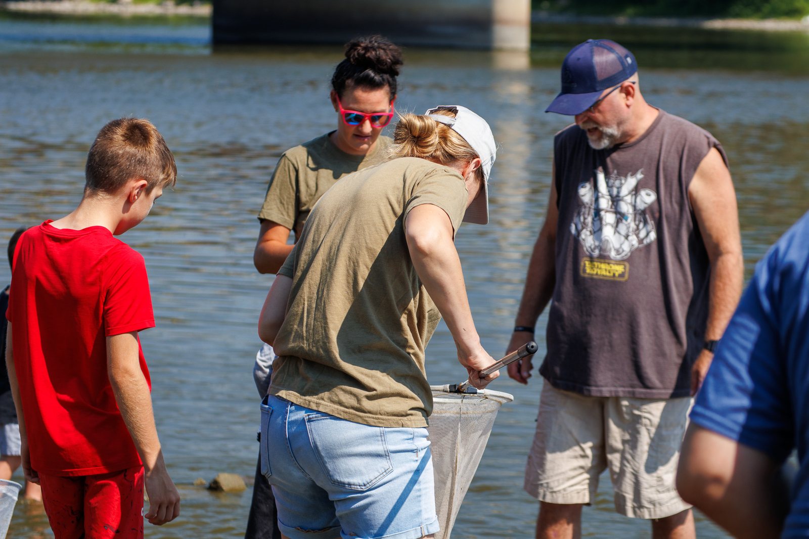 Pack families helping with a river conservation activity