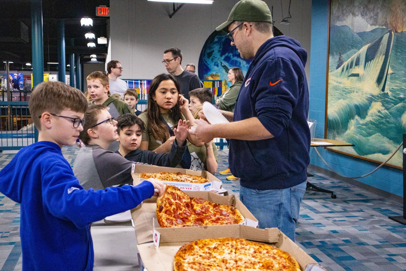 Pack families sharing pizza during an outing