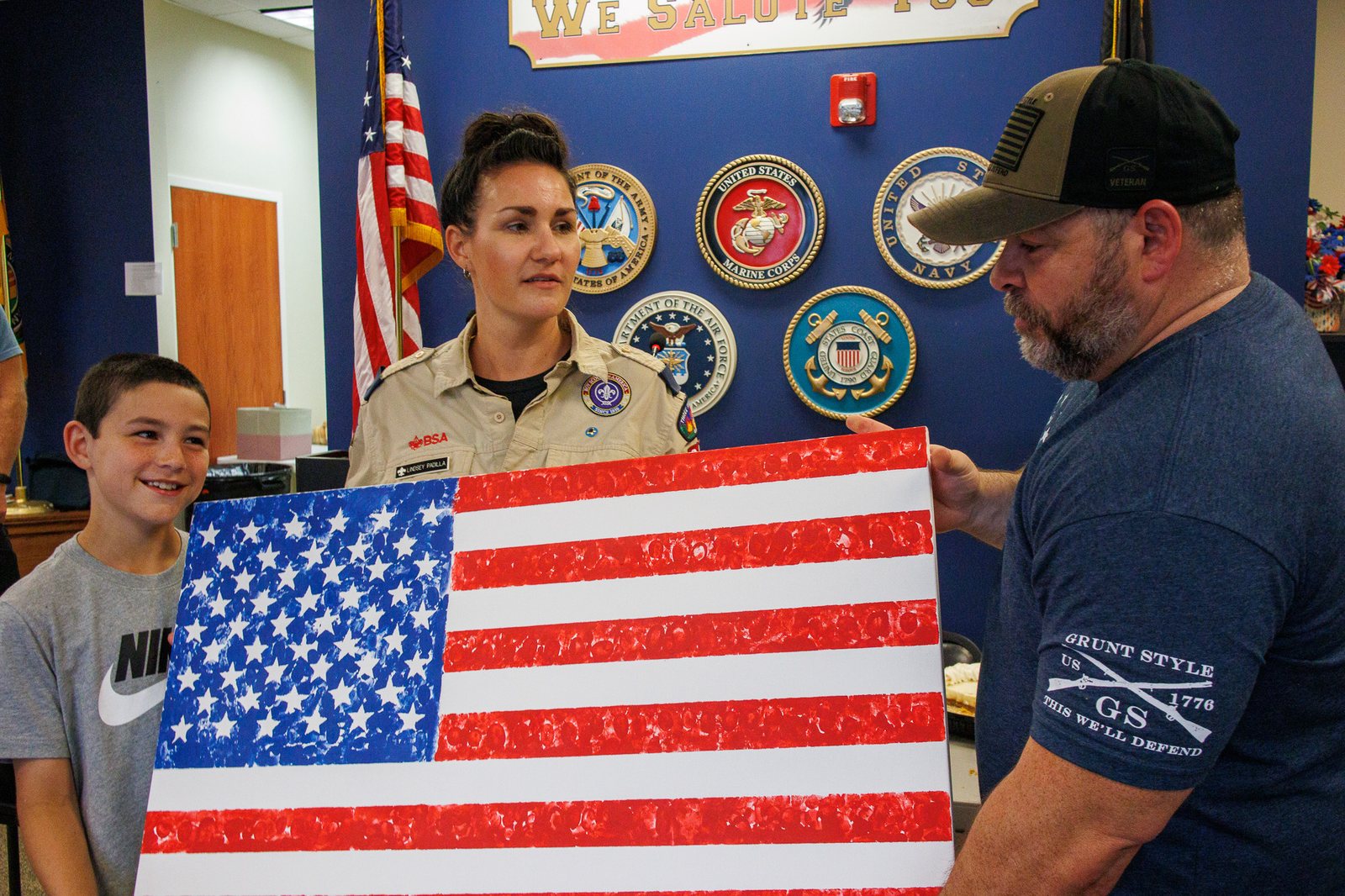 Scout presenting a handmade American flag to a veteran