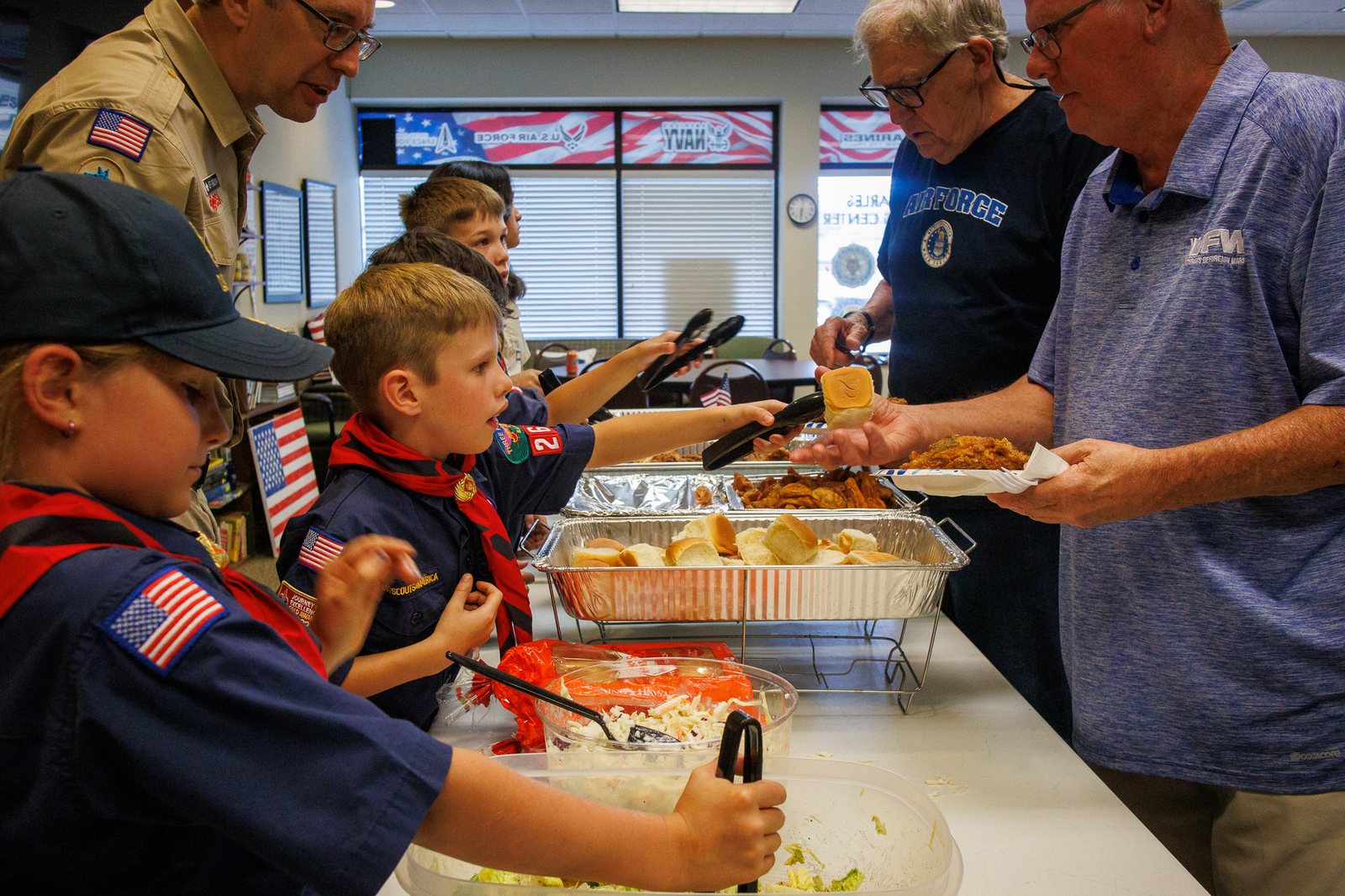 Cub Scouts serving a meal to veterans
