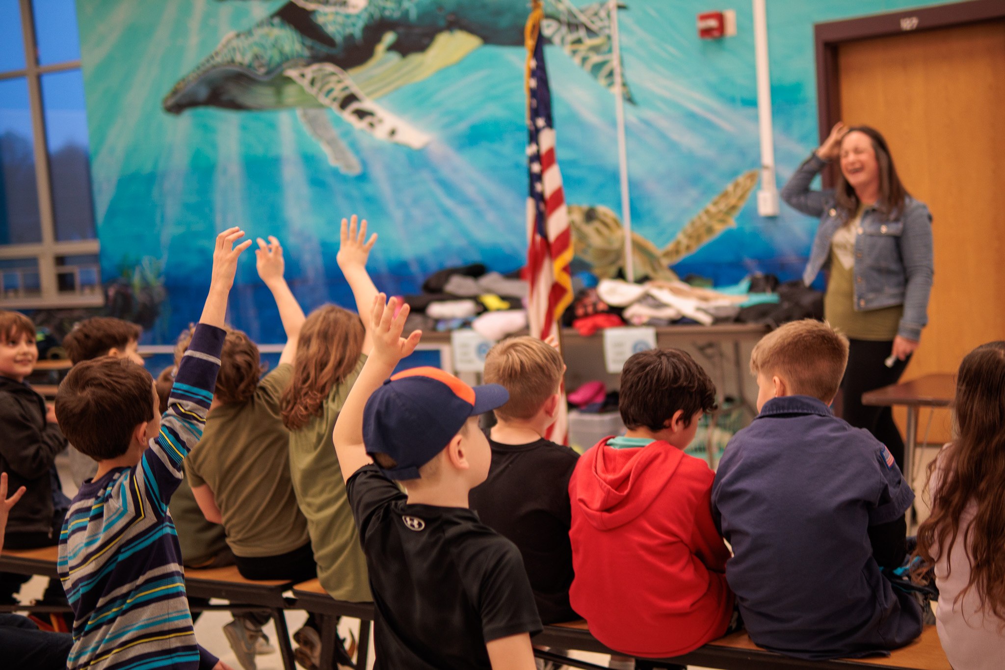 Pack 260 Scouts raising their hands during a group activity
